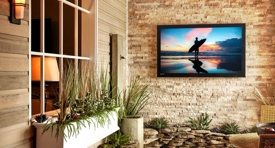 Outdoor TV on a patio overlooking the living room window and window box garden.