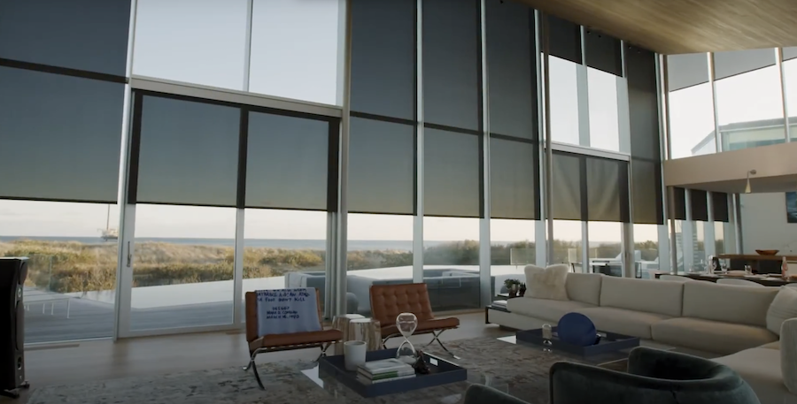 living room seating area with floor-to-ceiling windows in the background featuring automated shades to control sunlight.