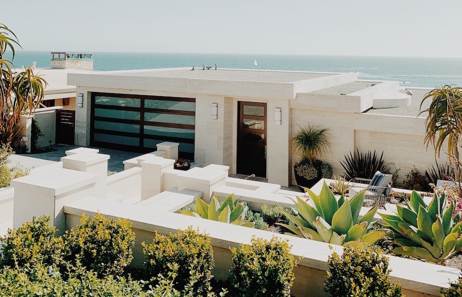 A contemporary beach house overlooking a beach view. The home has automated outdoor lighting and interior shades