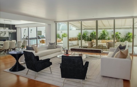 contemporary open concept dining and living room overlooking a patio with outdoor kitchen