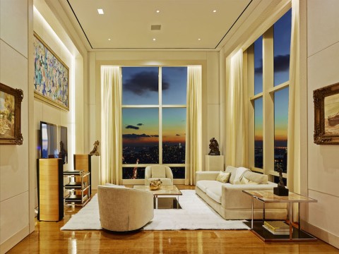 Close up of a home media room in a high rise featuring a flat screen TV, tower speakers and white sofas. 