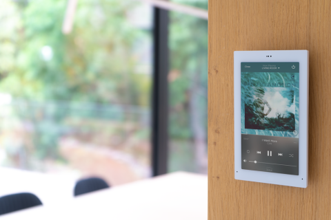A Savant control screen is mounted on the kitchen wall for easy access to smart home technology.
