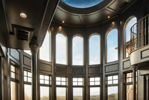 two-story luxury home ceiling with floor-to-ceiling windows and dimmed canned lighting.