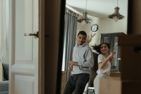 Couple dancing in the dining room of their home. 